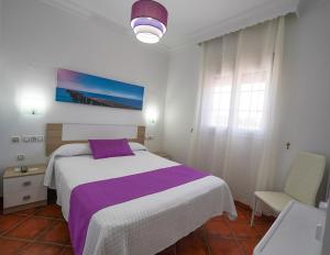科尼尔-德拉弗龙特拉洛斯麦雷斯旅馆的一间卧室配有一张大床和紫色毯子