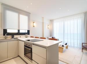 拉纳卡LIV Mackenzie Beach Suites Larnaca ADULTS ONLY的配有白色家电的厨房和客厅