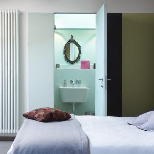 雷焦艾米利亚B&B Sottotetto的一间卧室配有床、水槽和镜子