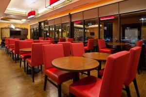卡尔斯巴德TownePlace Suites by Marriott Carlsbad的餐厅设有红色的椅子和桌子以及窗户。