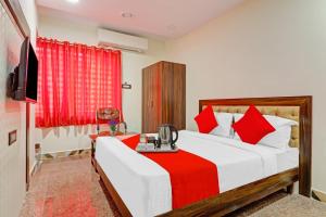 海得拉巴Heavens Inn Near Rasoolpura metro station的一间卧室配有一张带红色枕头的大床