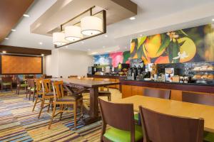休斯顿Fairfield by Marriott Inn & Suites Houston North/Cypress Station的一间带桌椅的餐厅和一间酒吧