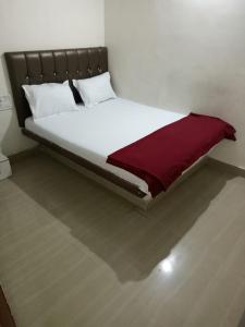 孟买Hotel janata Residency的一张白色的床,上面有一条红毯
