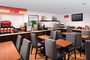 阿尔伯克基TownePlace Suites by Marriott Albuquerque Airport的一间带桌椅的餐厅和一间酒吧