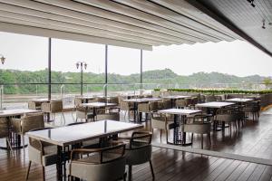 沙马林达沙马林达哈里斯酒店的餐厅设有桌椅和大窗户。