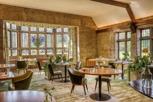 科姆堡The Manor House Hotel and Golf Club的餐厅设有桌椅和窗户。