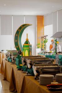 沙马林达沙马林达哈里斯酒店的厨房里一排桌子,上面有盘子
