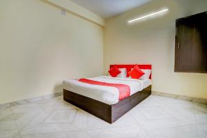 布巴内什瓦尔OYO Avisi Residency的一间卧室配有一张带红色枕头的大床