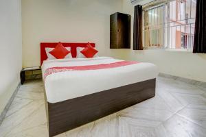 布巴内什瓦尔OYO Avisi Residency的一间卧室配有一张带红色枕头的大床