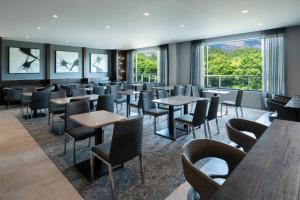 梅德福TownePlace Suites by Marriott Boston Medford的餐厅设有桌椅和窗户。