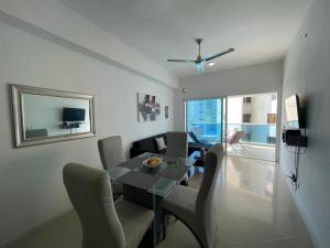 卡塔赫纳Apartamento lujoso a un minuto de la playa del laguito, la mejor playa de Cartagena de Indias的客厅配有桌椅和沙发