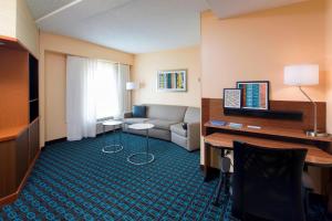纽瓦克纽瓦克自由国际机场万豪费尔菲尔德套房酒店的一间客厅,客厅配有沙发和一张书桌,位于酒店的房间