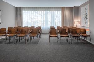 韦尔瓦韦尔瓦万豪AC酒店的一个带椅子和大窗户的会议室