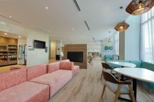 坎昆Residence Inn by Marriott Cancun Hotel Zone的客厅配有粉红色的沙发和桌子
