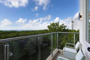 坎昆Residence Inn by Marriott Cancun Hotel Zone的享有森林美景的阳台