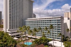檀香山喜来登凯拉尼公主酒店的一座棕榈树环绕的大建筑