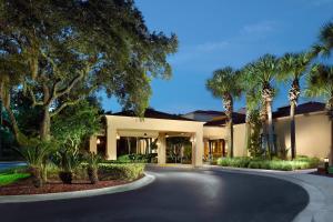 杰克逊维尔Courtyard by Marriott Jacksonville at the Mayo Clinic Campus/Beaches的棕榈树房屋和车道