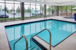 绿湾绿湾春丘套房酒店的一座大型游泳池,位于一座带窗户的建筑内