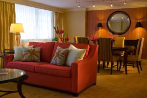 巴尔的摩巴尔的摩坎登球场内港万豪酒店的一间带红色沙发的客厅和一间用餐室