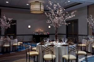 巴尔的摩巴尔的摩坎登球场内港万豪酒店的一个带桌椅的宴会厅,配有 ⁇ 