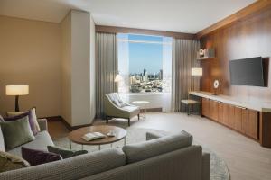 科威特Marriott Executive Apartments Kuwait City的带沙发和电视的客厅