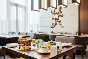 科威特Marriott Executive Apartments Kuwait City的用餐室配有餐桌和食物
