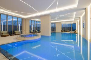 科威特Marriott Executive Apartments Kuwait City的蓝色地板和窗户的酒店游泳池