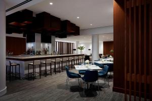 尤宁戴尔长岛万豪酒店的一间带桌椅的餐厅和一间酒吧