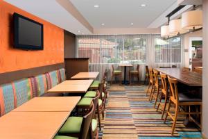 阿尔伯克基波特兰机场万豪费尔菲尔德套房酒店的一间带桌椅的餐厅以及墙上的电视