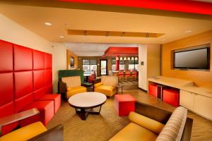 布里奇波特布里奇波特克拉克斯堡万豪广场套房酒店的一间配备有橙色和红色家具及平面电视的等候室