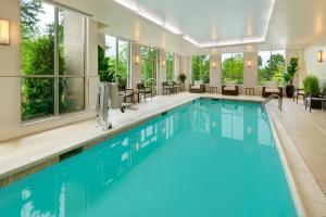 阿尔法利塔Courtyard by Marriott Atlanta Alpharetta/Avalon Area的一座配有桌椅的酒店游泳池
