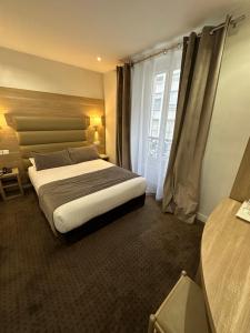 巴黎阿根诺酒店的一间卧室设有一张大床和一个窗户。