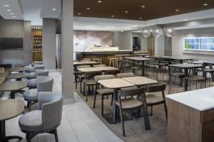 温莎SpringHill Suites by Marriott Loveland Fort Collins/Windsor的一间带桌椅的餐厅和一间酒吧
