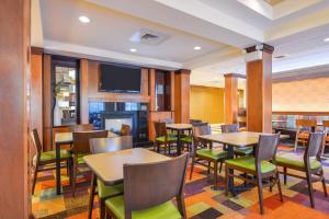 巴尔的摩怀特马什费尔菲尔德旅馆&套房酒店的餐厅设有桌椅和平面电视。