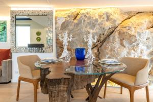 卡普里Casa Boutique by Capri 5 Senses的一间设有玻璃桌和椅子的用餐室