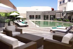 普埃布拉拉斯阿尼马斯普埃布拉万怡酒店的一座游泳池旁,设有沙发和椅子