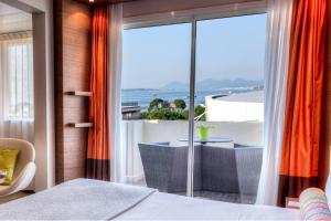 胡安莱潘安提布 - 瑞昂莱潘大使万豪AC酒店的一间卧室设有海景阳台