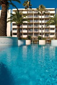 胡安莱潘安提布 - 瑞昂莱潘大使万豪AC酒店的棕榈树酒店前的游泳池