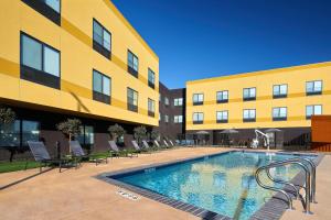 弗雷斯诺Fairfield Inn & Suites by Marriott Fresno Yosemite International Airport的大楼前的游泳池