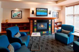 明尼阿波利斯明尼阿波利斯市区/北环万豪广场套房酒店的客厅配有蓝色椅子和壁炉