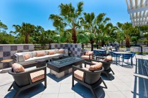 莱克兰SpringHill Suites Lakeland的一个带沙发和桌子及棕榈树的庭院