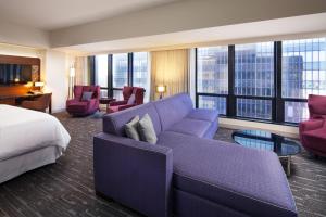 洛杉矶洛杉矶喜来登大酒店的酒店客房配有紫色沙发和床。