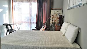SandtonLonehill的一间卧室配有一张床,窗户配有吉他