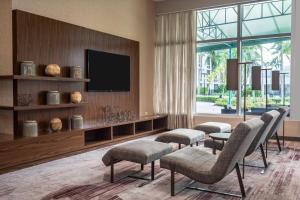 迈阿密迈阿密机场万怡酒店的客厅配有平面电视和椅子