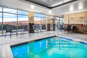 克拉马斯福尔斯Fairfield Inn & Suites by Marriott Klamath Falls的一个带桌椅的游泳池和一个用餐室