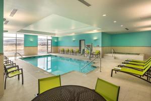 里诺SpringHill Suites by Marriott Reno的一个带绿色椅子和台球桌的大型游泳池