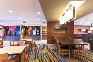 迪科拉Fairfield Inn & Suites by Marriott Decorah的一间带桌椅和电视的用餐室
