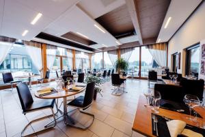 赛尼厄莱吉耶Jura Sport & Spa Resort的餐厅设有桌椅和大窗户。