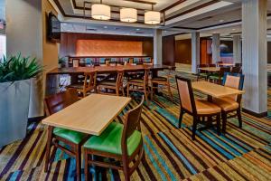 俄克拉何马城俄克拉荷马城机场万豪费尔菲尔德套房酒店的用餐室配有木桌和椅子