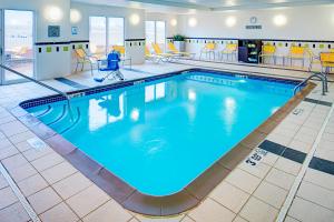 琼斯伯勒琼斯伯勒万豪费尔菲尔德客栈及套房酒店的蓝色水面的酒店客房内的大型游泳池